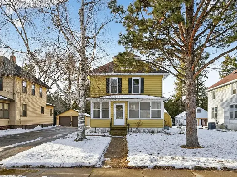 Older two-story home on a snowy residential street in Rochester, MN